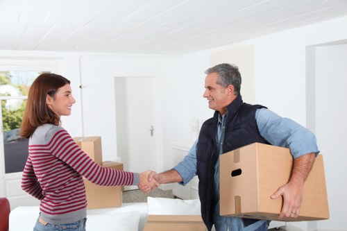 Mover carrying wrapped furniture through a property hallway