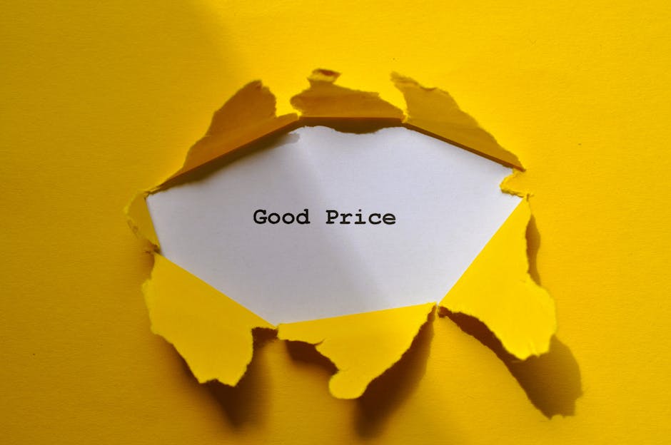 A white card with the words 'Good Price' printed in black is partially visible through a torn yellow paper covering, creating a circular opening on a yellow background. The torn edges of the paper are